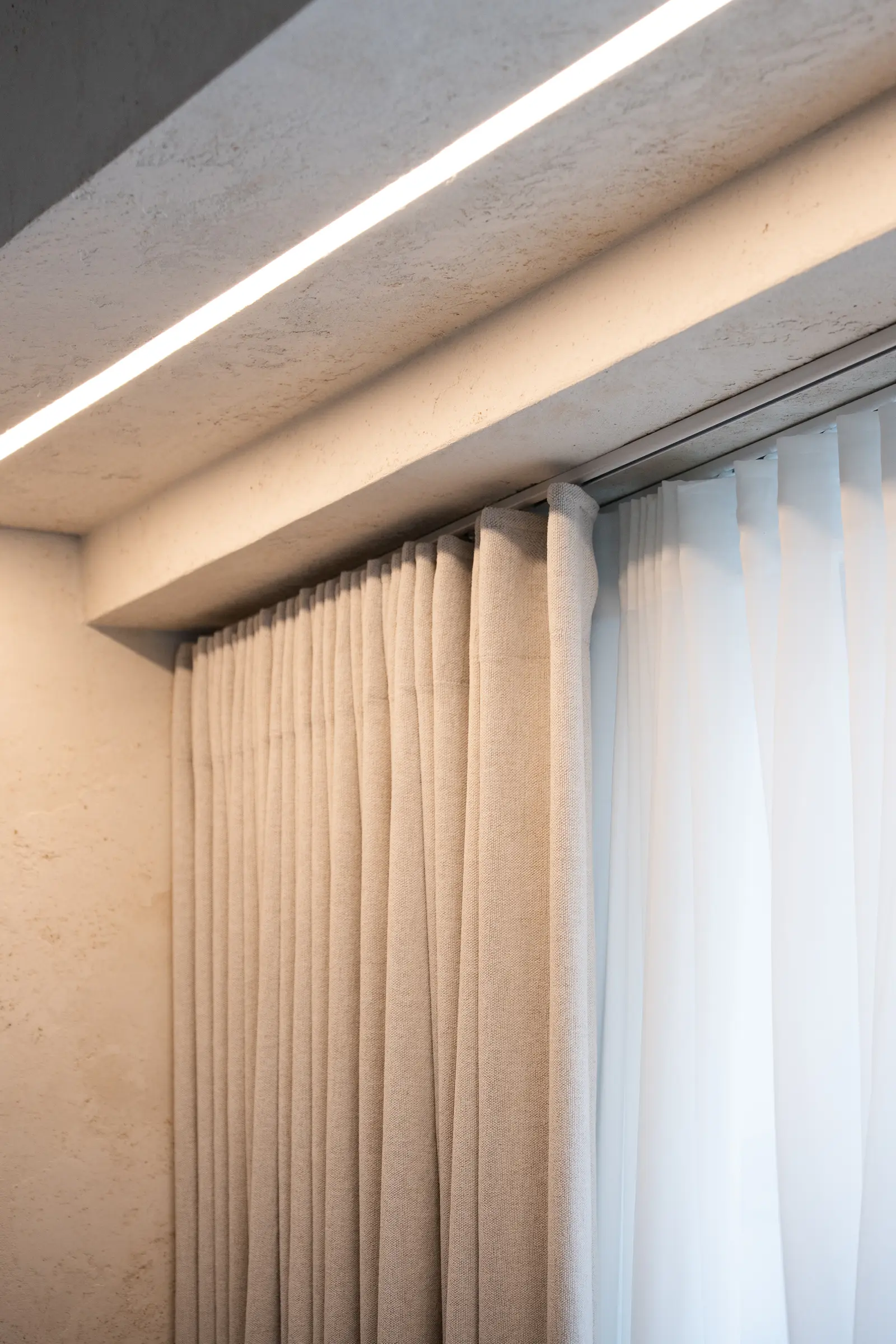 Lubinis bėgelis betono nišoje su LED apšvietimu — šviesa nesiprasmunkia pro šonus